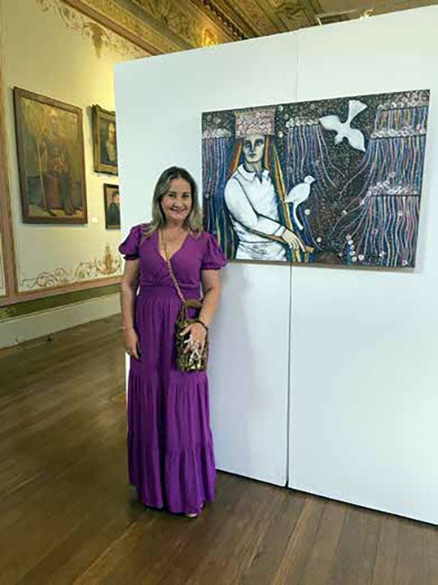 Trajetória artística de Adriana Coimbra em exposição ao lado de uma de suas obras