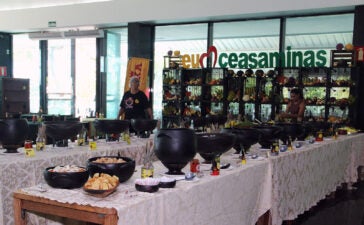 Buffet da Feijoada do Maranhão com panelas e acompanhamentos dispostos sobre mesas