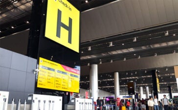 Área de check-in do GRU Airport com passageiros no terminal