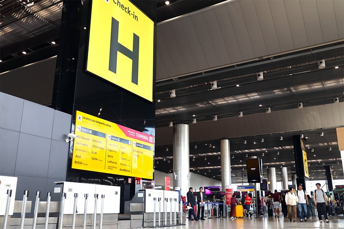 Área de check-in do GRU Airport com passageiros no terminal