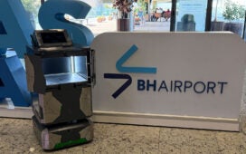 Robô de entregas no BH Airport ao lado da sinalização do terminal