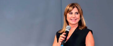 Mestre de cerimônias Cássia Farah segurando um microfone