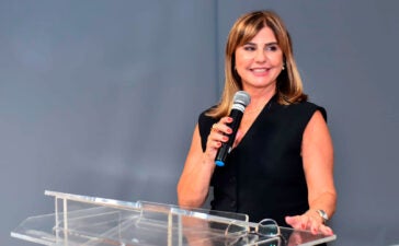 Mestre de cerimônias Cássia Farah segurando um microfone
